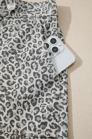 Denim shorts with leopard print and a pocket holding a phone.