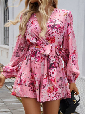 Floral wrap romper in Dusty Pink with blouson sleeves and a tie waist.