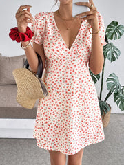 Floral V-neck puff sleeve mini dress with red floral print on white fabric.