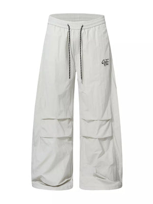 Men's cream white wide-leg cargo pants with drawstring waist and multiple flap pockets.