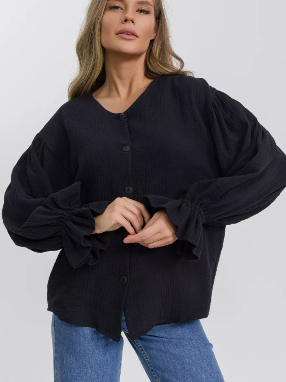 Black textured puff sleeve blouse with ruffled cuffs and button front
