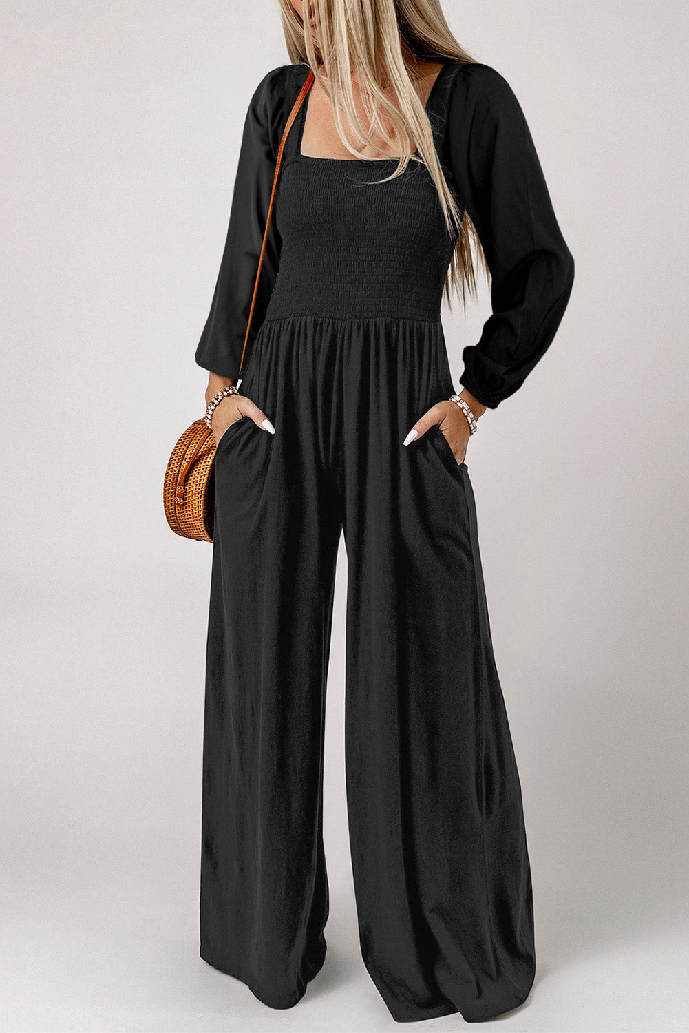 Black smocked bodice wide leg jumpsuit with square neckline and long sleeves.