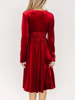 Red velvet midi dress with smocked waist and long sleeves, shown from the back.