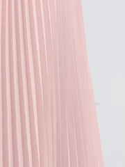 Pink pleated skirt detail of a two-piece ensemble