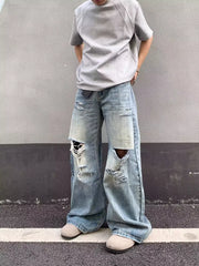 Distressed light wash wide-leg jeans with pocket detail and ripped knees.