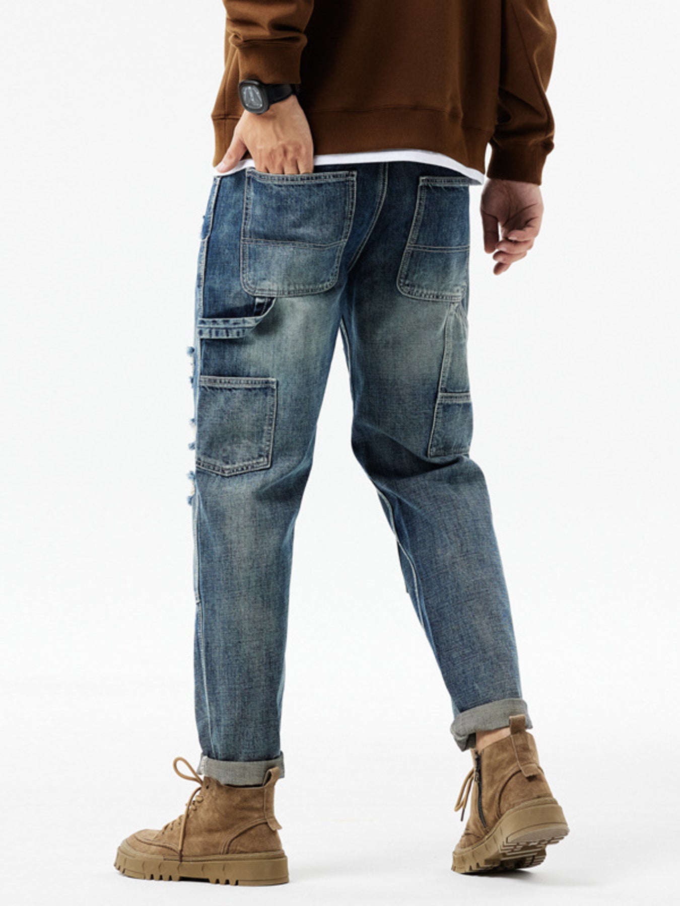 Men's distressed blue denim jeans with utility loop and multiple pockets.