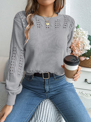 Gray knit sweater with openwork sleeves and distressed hem.