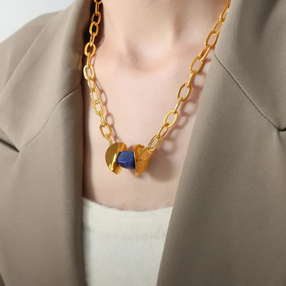 Geometric malachite pendant necklace with 18K gold-plated chain and dark blue stone.