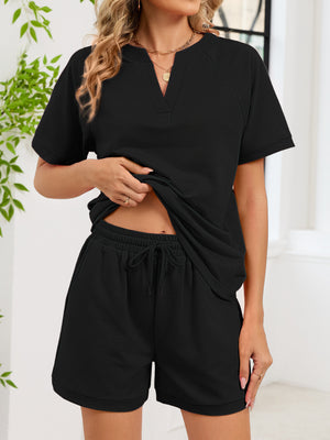 Black loungewear shorts with drawstring waist and cuffed hem, paired with a matching V-neck top.