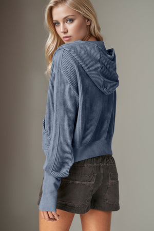 Textured knit bomber hoodie in dusty blue with waffle texture and front pockets.