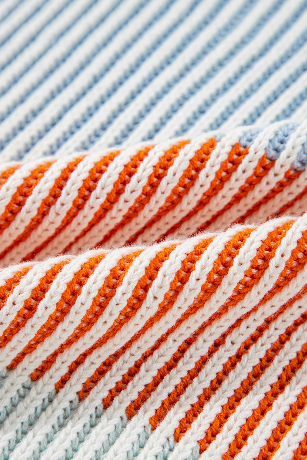 Ribbed knit sweater with diagonal stripes in cream, orange, and dusty blue acrylic.