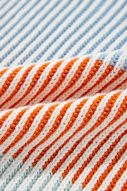 Ribbed knit sweater with diagonal stripes in cream, orange, and dusty blue acrylic.