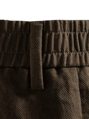 Classic pleated chino shorts in coffee brown with elastic waistband detail.