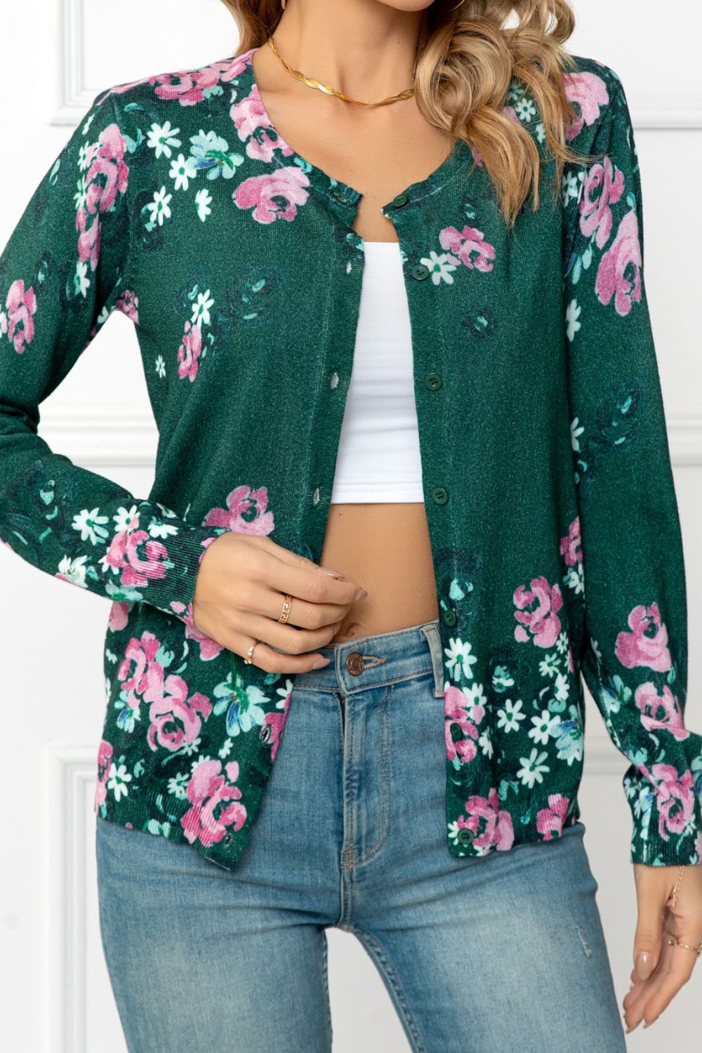 Forest green crewneck cardigan with a pink and white floral print, button front, and long sleeves.