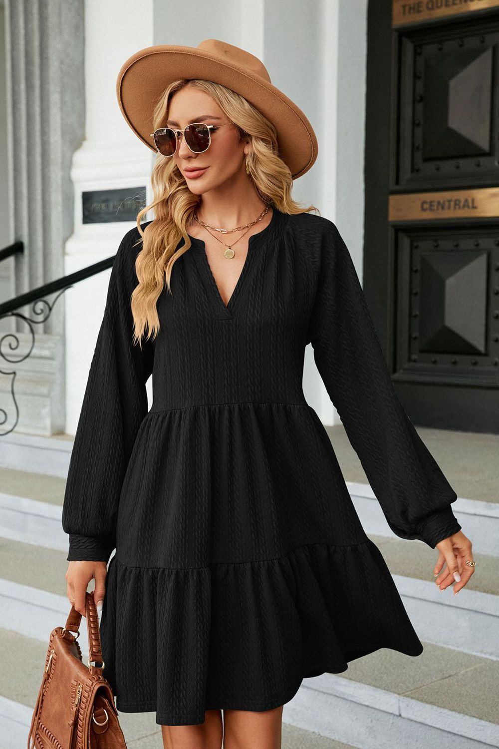 Black textured babydoll mini dress with voluminous sleeves and tiered hem