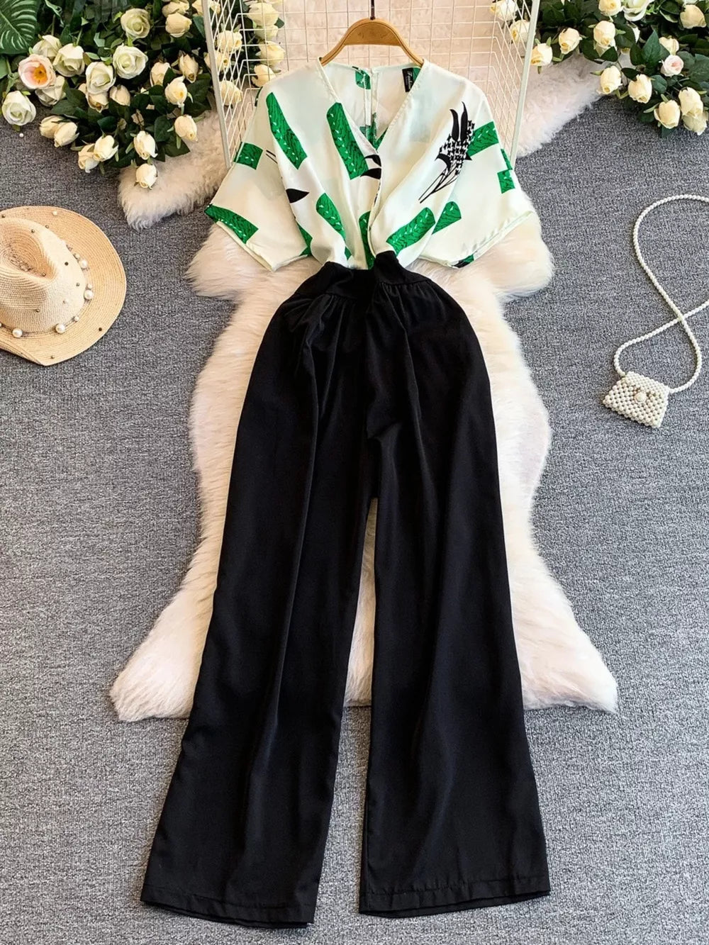 Black wide-leg romper with abstract green print top and pockets.