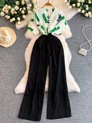 Black wide-leg romper with abstract green print top and pockets.