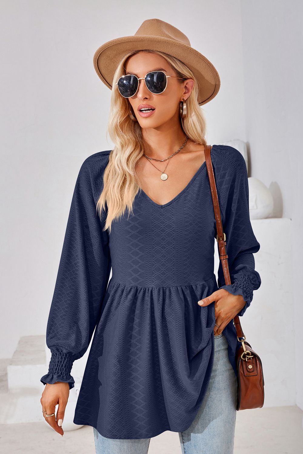 Dark blue textured babydoll blouse with v-neck and smocked cuffs