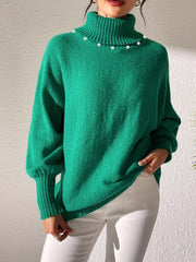 Green knit sweater with pearl-embellished turtleneck and dolman sleeves.