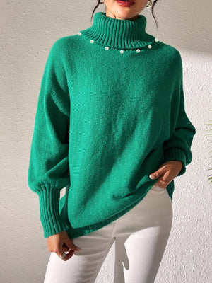 Green knit sweater with pearl-embellished turtleneck and dolman sleeves.