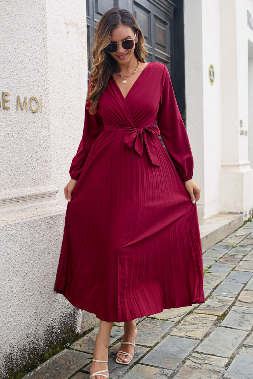 Wine pleated maxi dress with V-neck, long sleeves, and wrap-tie waist.