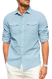 Light blue linen utility shirt with two chest pockets and rolled sleeves.
