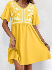 Yellow embroidered floral v-neck mini dress with short sleeves and a flowy skirt.