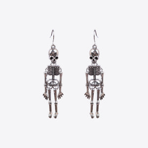 Skeleton silhouette drop earrings in silver with intricate bone detail.