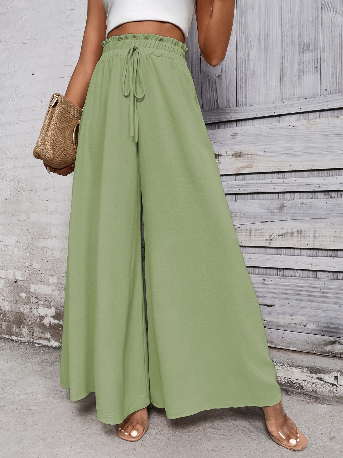 Light green ruffled waistline palazzo trousers with drawstring waist and wide legs.