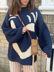 Dark blue knit sweater with abstract cream graphic, crew neck, and relaxed fit.