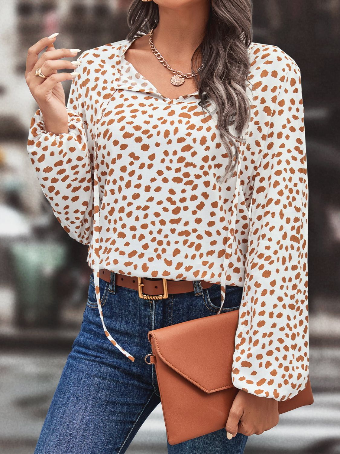 White blouse with brown animal print, tie-neck, long sleeves, and a relaxed fit.