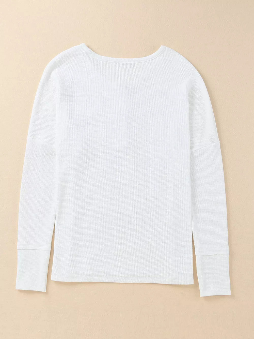 White textured cotton henley shirt with long sleeves and button detail.