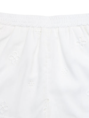 White embroidered shorts with elastic waistband and floral eyelet details.