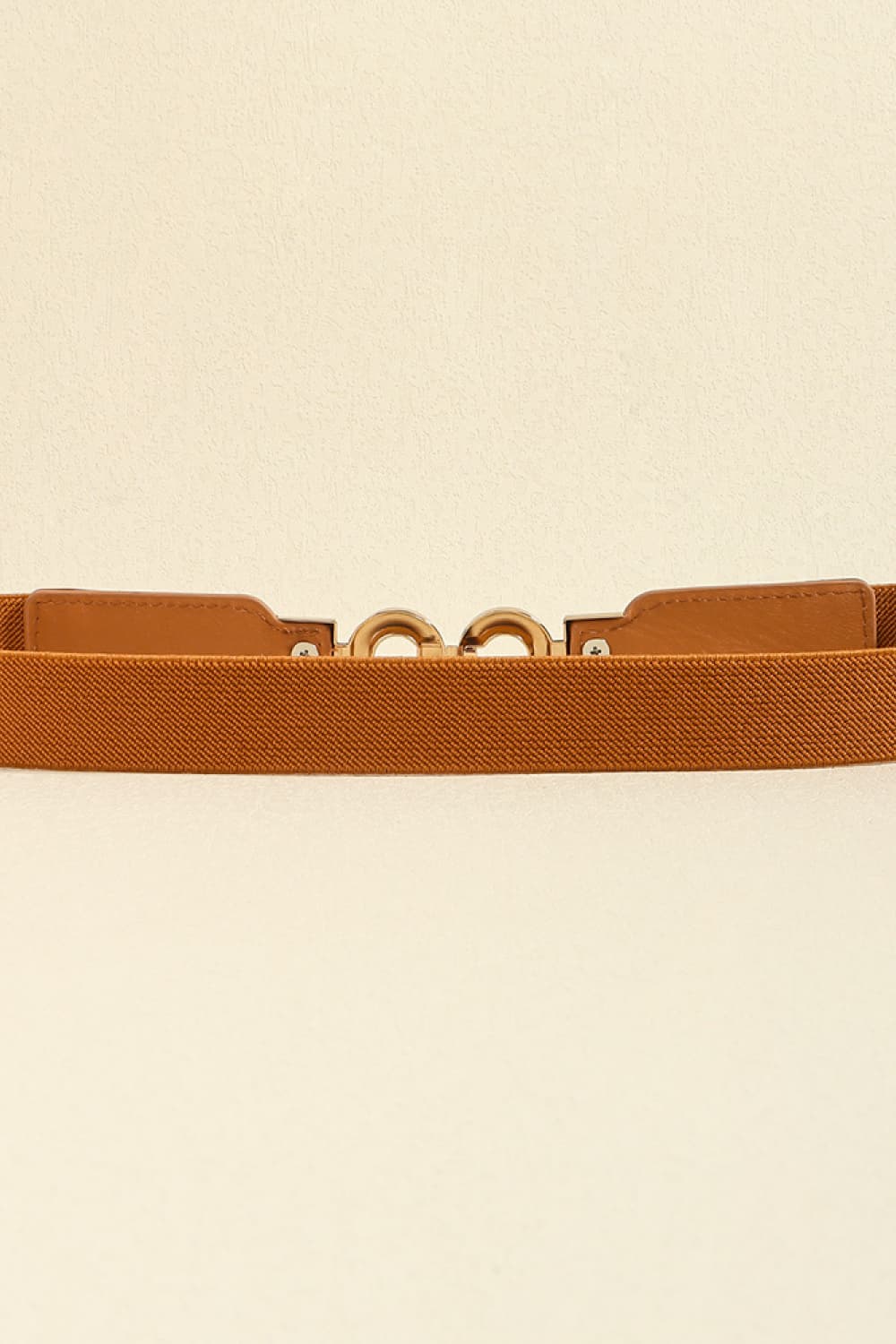 Caramel elastic belt with gold interlocking buckle detail and faux leather tab