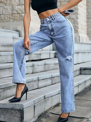 Ripped high-waisted light wash denim jeans with button closure and straight leg cut.