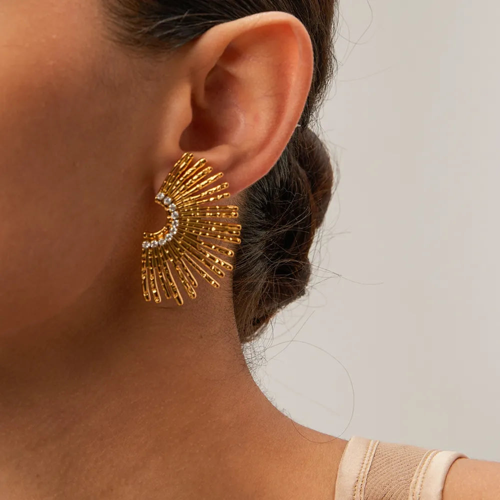 Gold fan earrings with crystal accents and textured rays.