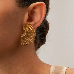 Gold fan earrings with crystal accents and textured rays.
