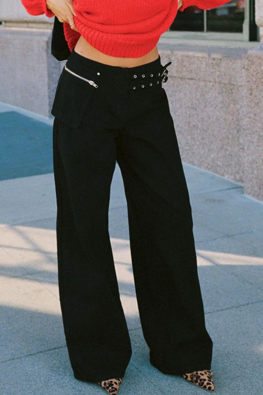 Black flared denim trousers with utility buckle detail and zipper pocket
