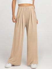 Pleated palazzo trousers in taupe with pockets and elastic waistband.