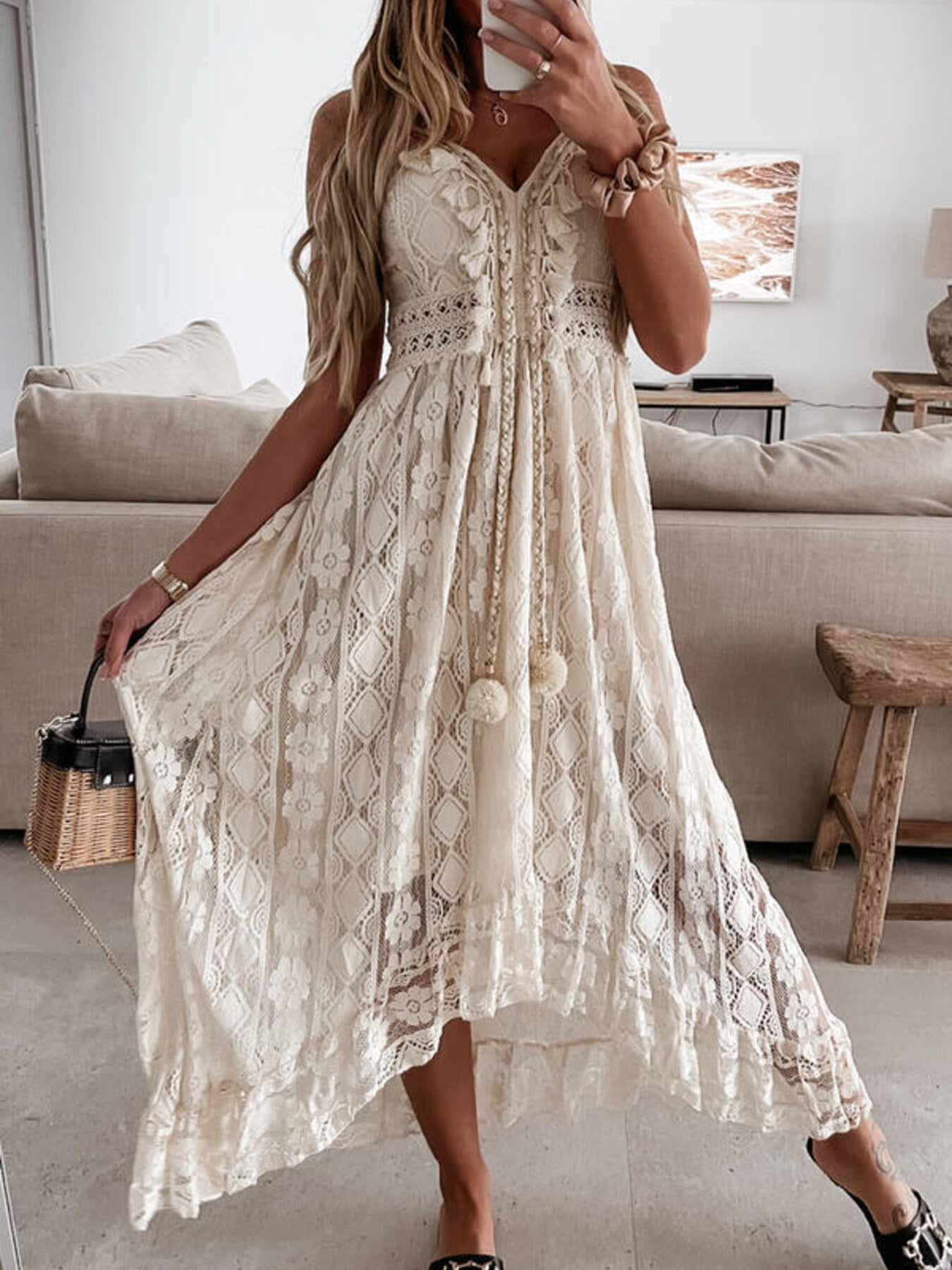 Beige lace V-neck maxi dress with ruffles and tassel detail.