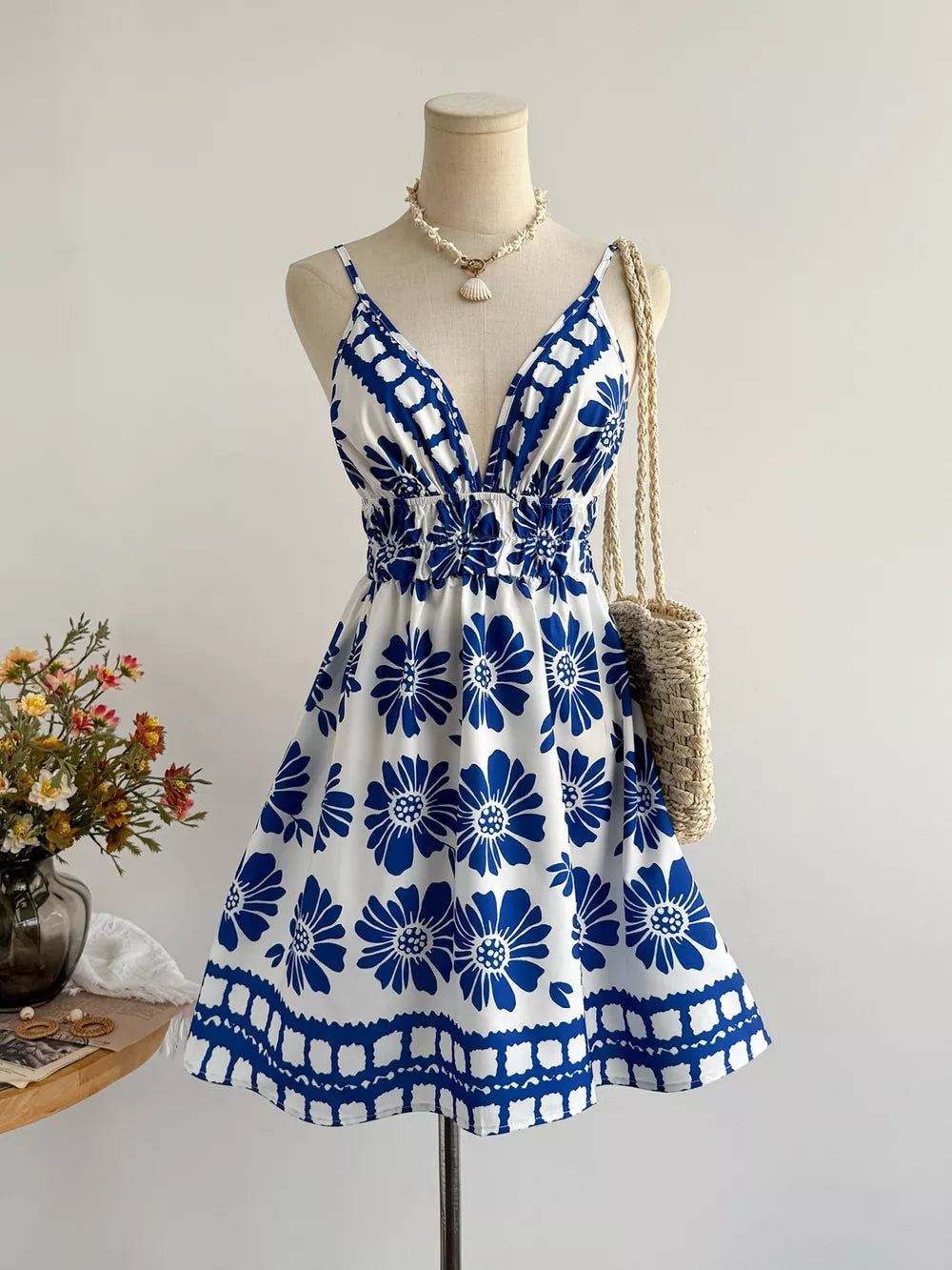 White and blue floral v-neck mini dress with smocked waist and a-line skirt.