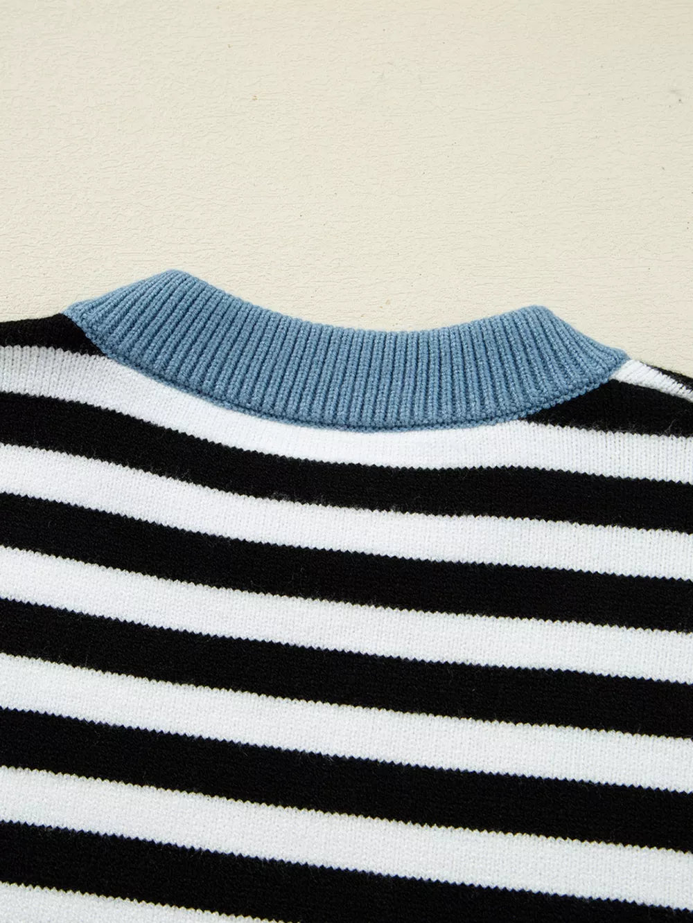 Colorblock striped knit sweater with crew neck and blue ribbed collar detail.