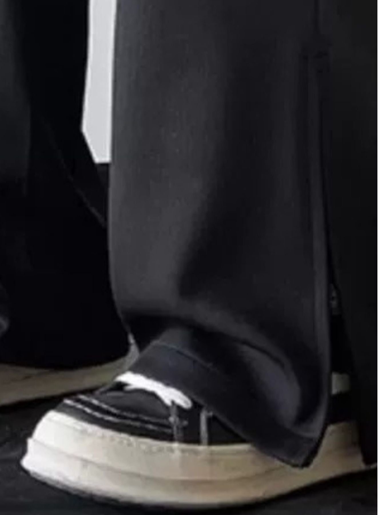 Men's black relaxed fit sweatpants with drawstring and side slit detail.