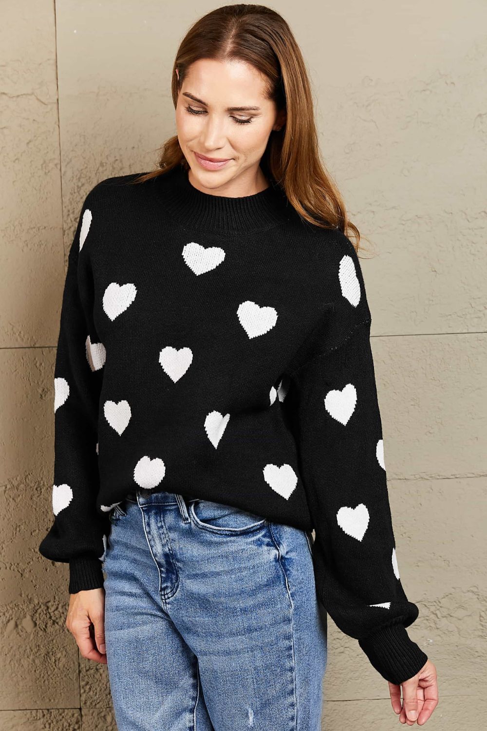 Black sweater with white hearts, mock neck, and balloon sleeves.