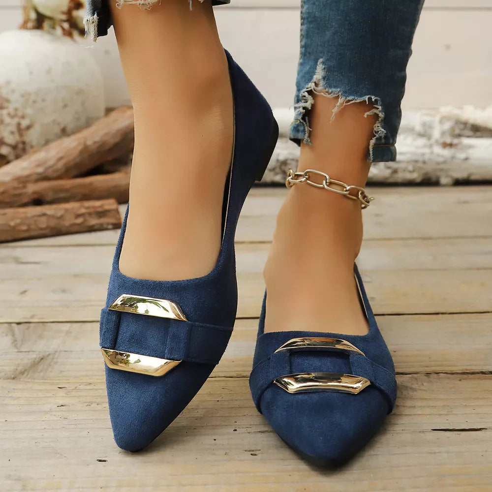 Navy blue slip-on flats with pointed toes and gold buckle detail.
