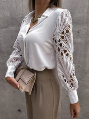 White collared blouse with intricate lace cutout sleeves and buttoned front.