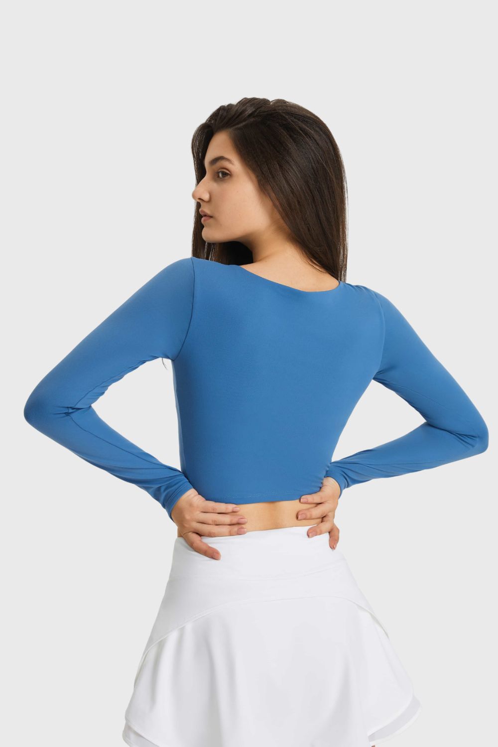 Blue long sleeve crop top with thumbhole sleeves and a keyhole neckline.