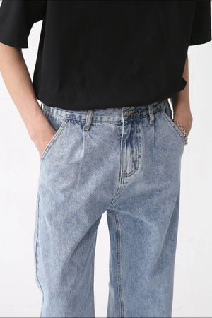 Pleated denim wide-leg trousers in medium wash, featuring a relaxed fit and casual style.