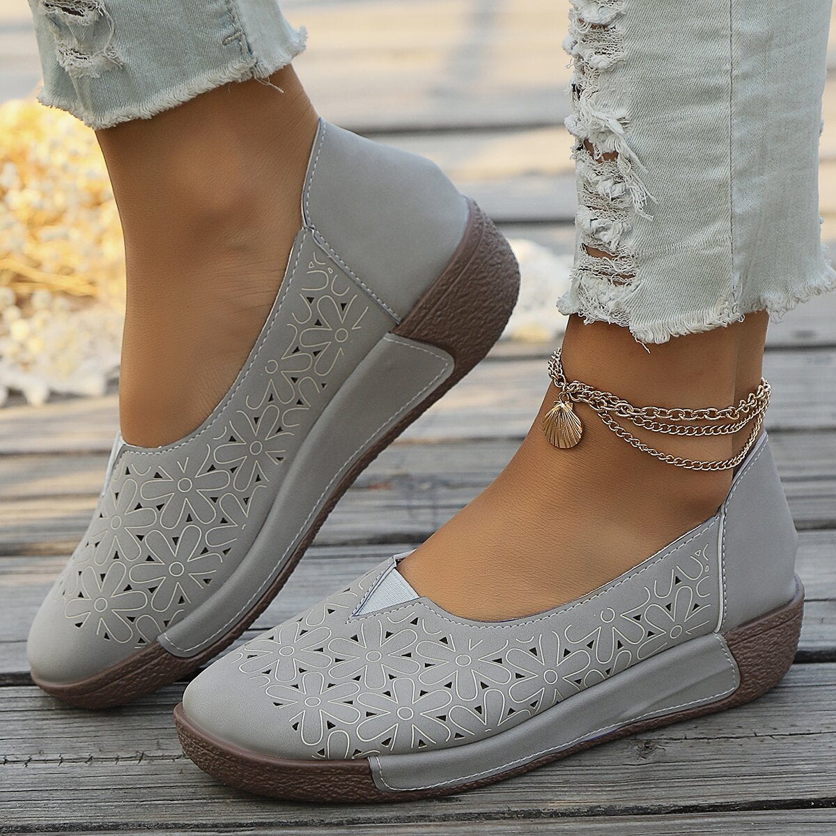 Grey floral cutout slip-on loafers with a comfortable sole and ankle chain detail.