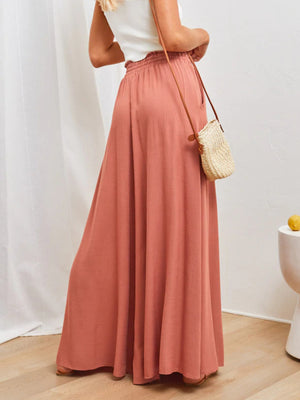 Coral maternity palazzo pants with gathered waist and wide legs.